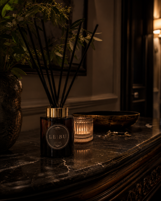 LE BU 100ml reed diffuser in dark green glass with gold collar and black reeds styled in a moody heritage interior