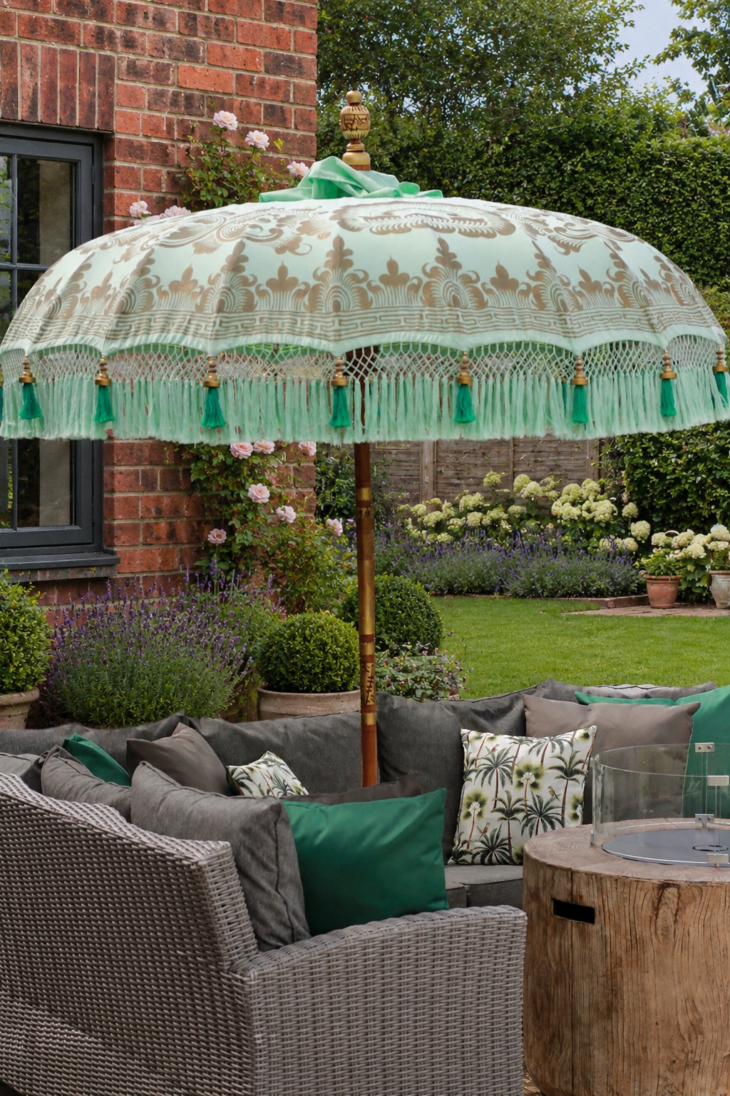 Handmade Balinese-style mint garden parasol with decorative tassel fringe in a classic English patio garden