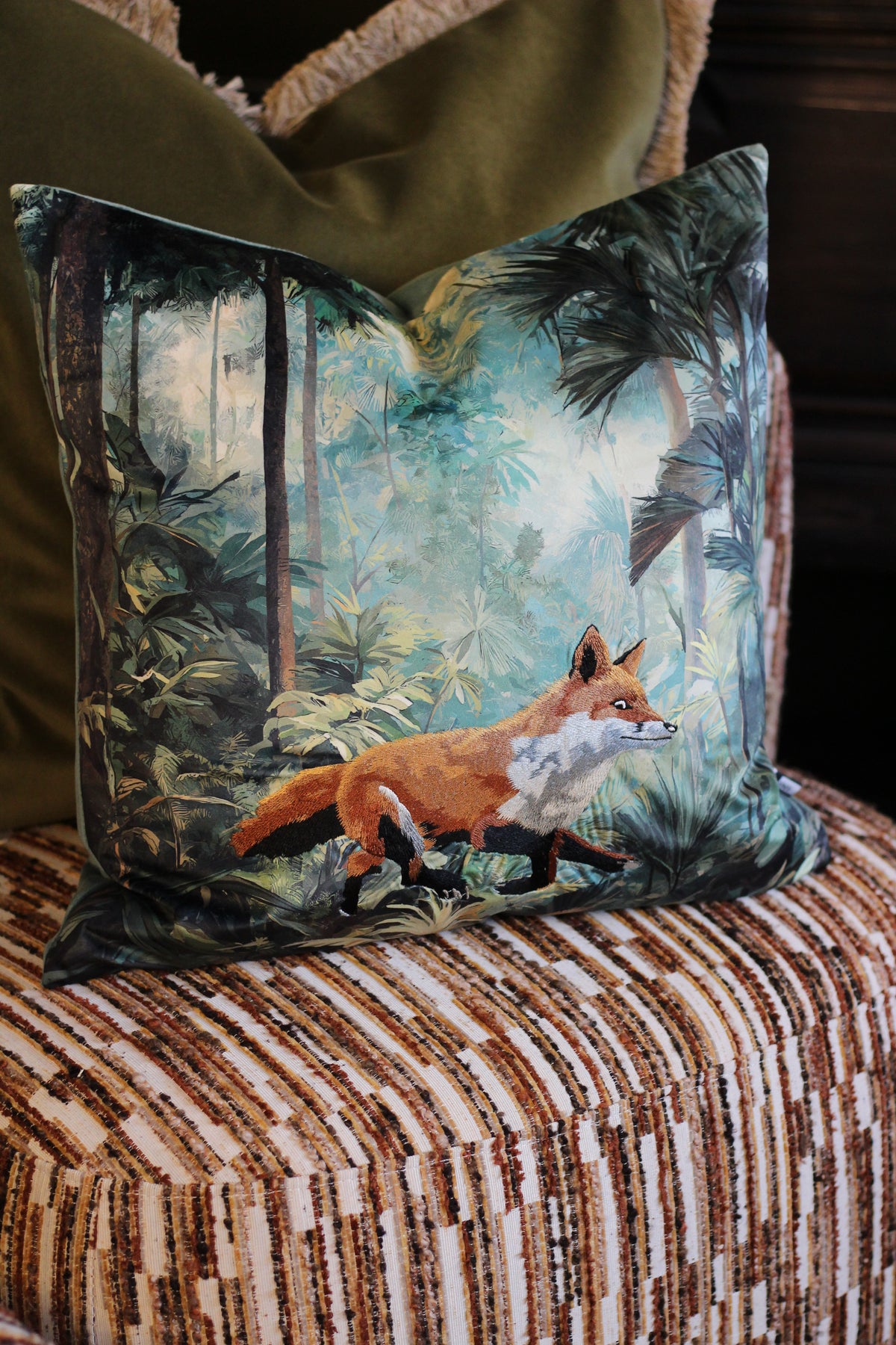 Front of Bracken embroidered fox cushion showing rust fox and leafy teal forest design
