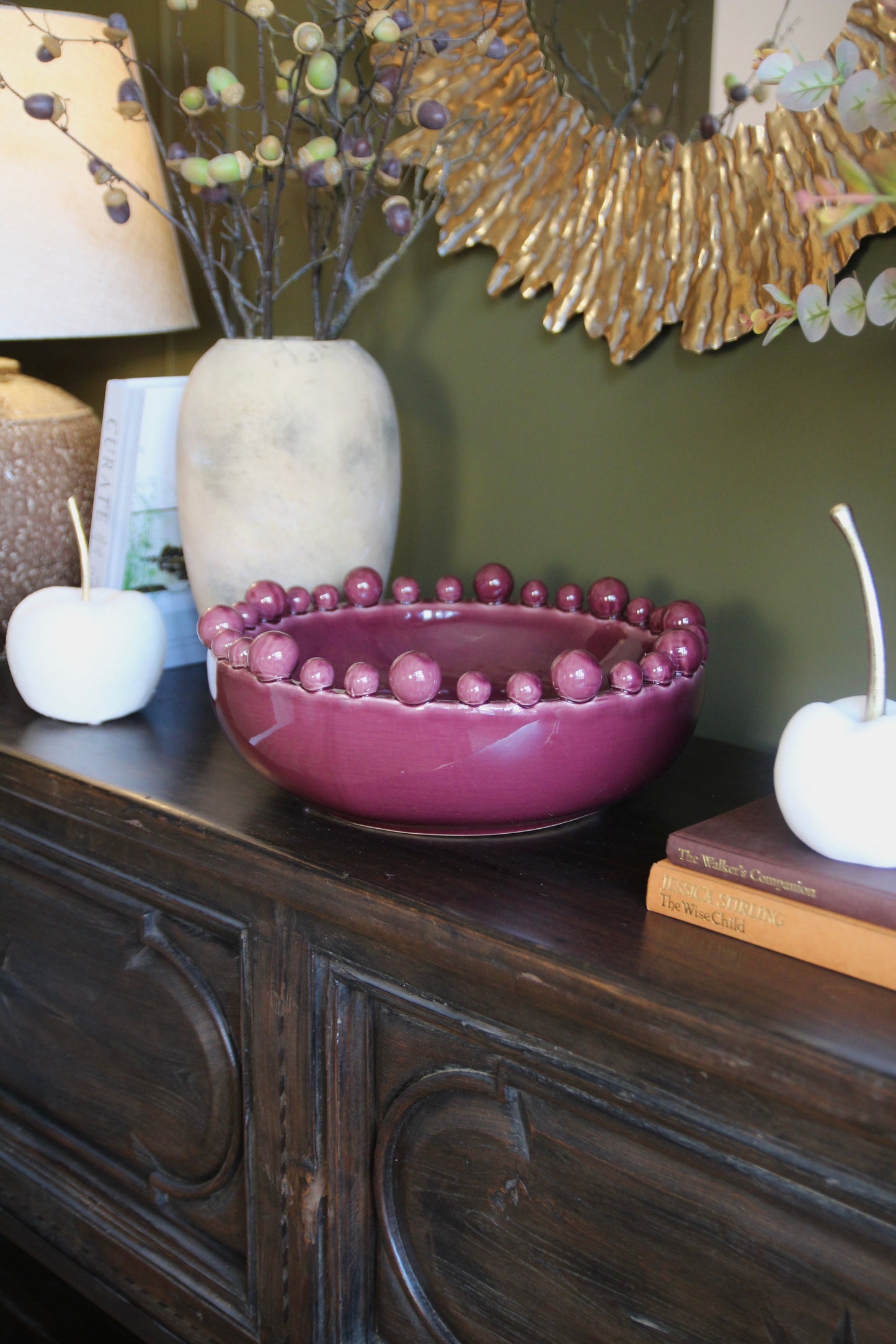Detail of the glazed burgundy ceramic bowl and rounded bobble edge